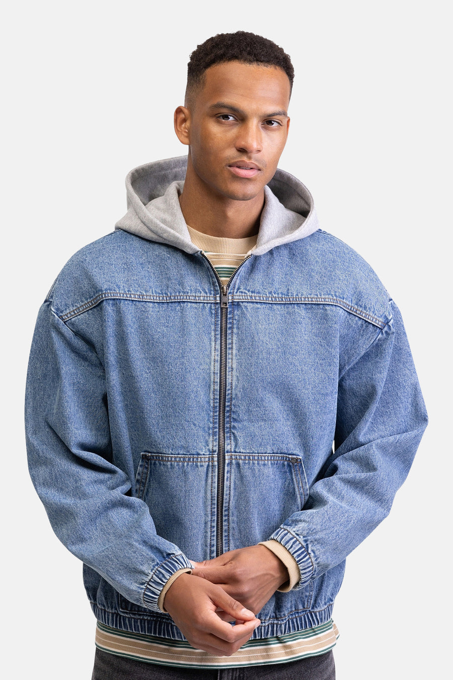 Veste en jean REDEFINED REBEL en denim bleu moyen, avec une capuche grise et une fermeture éclair sur le devant.