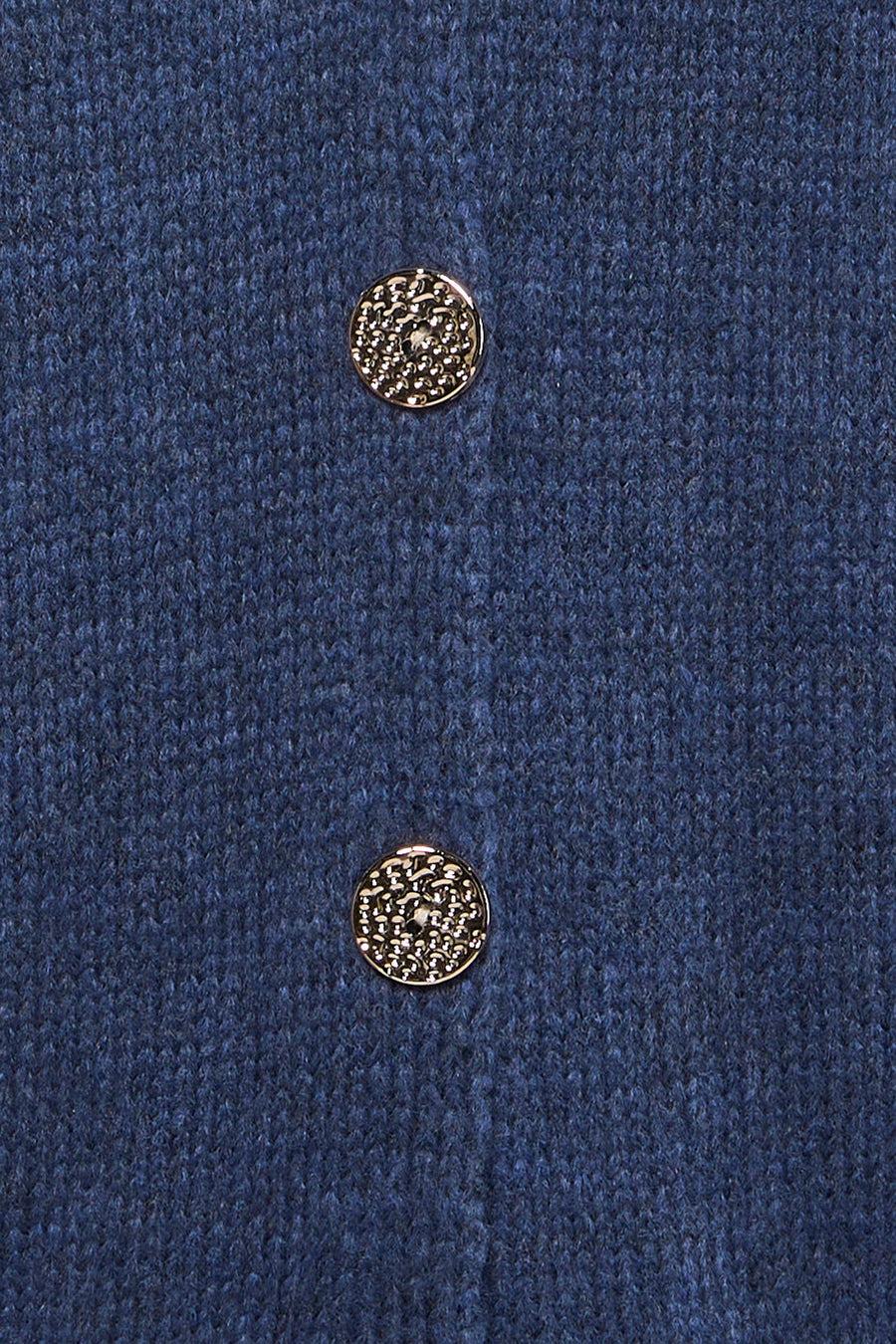 Gilet bleu de Terra di Siena avec boutons dorés et une texture tricot fine.