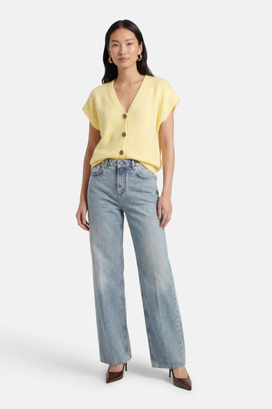 Geel gilet van Terra di Siena, met knopen en gedragen met een wijde jeans en bruine pumps.
