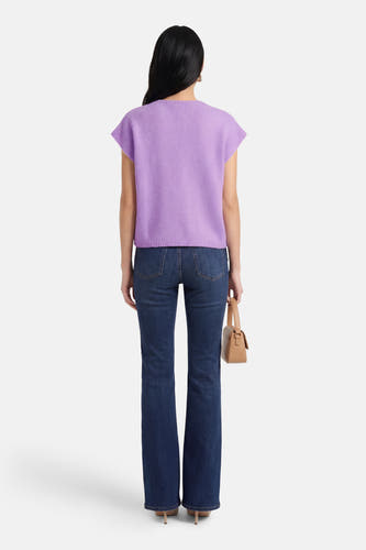 Gilet violet Terra di Siena, avec une texture finement tricotée, porté avec un jean foncé et un sac à main.