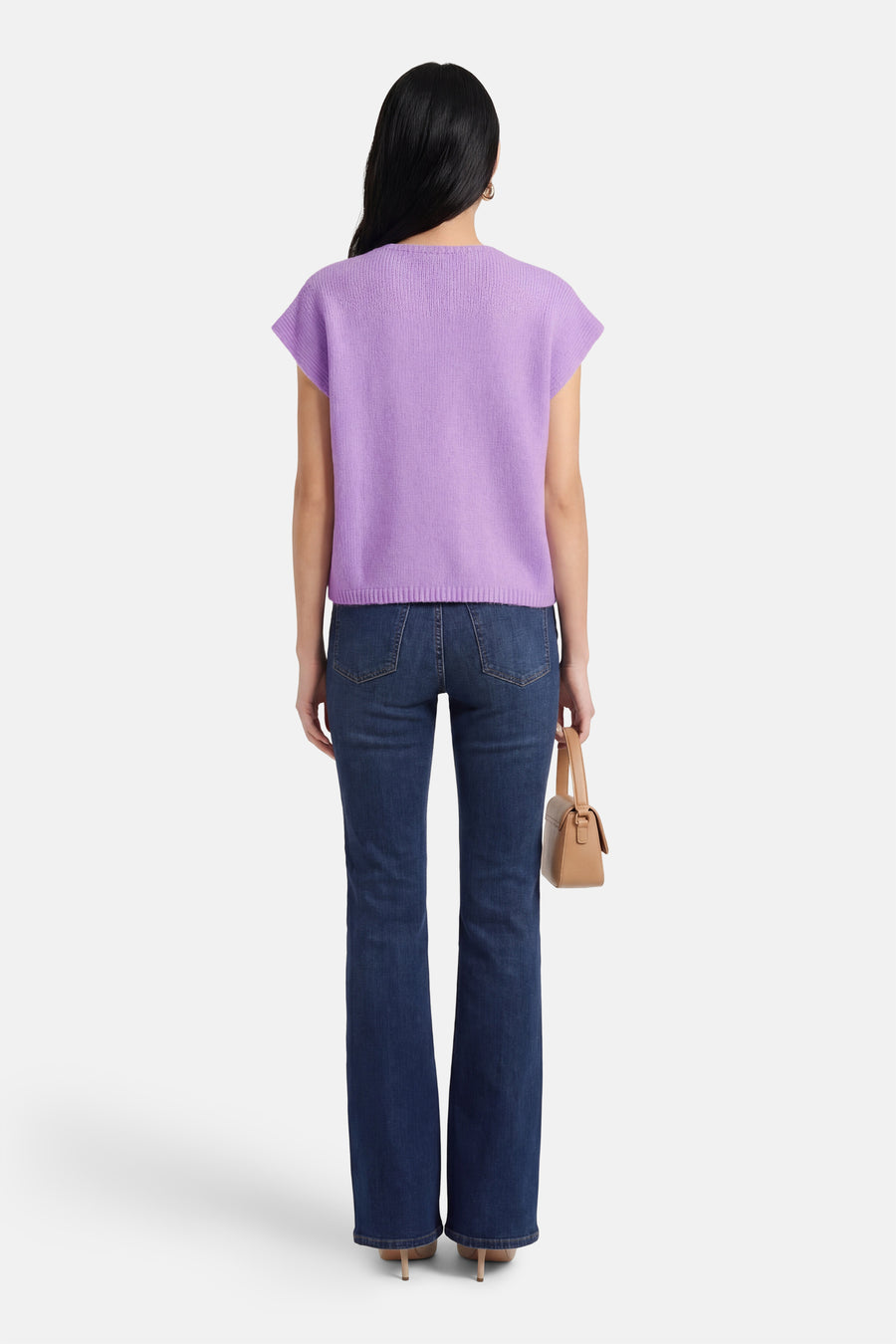 Gilet violet Terra di Siena, avec une texture finement tricotée, porté avec un jean foncé et un sac à main.