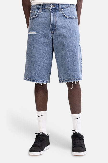 Short en jean bleu moyen de REDEFINED REBEL, vu de dos avec ourlets effilochés et deux poches arrière.