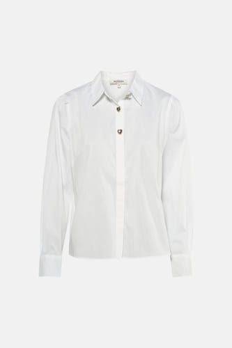 Chemise blanche à manches courtes de Morgan De Toi, avec des boutons en forme de cœur et portée avec un jean et des sandales.