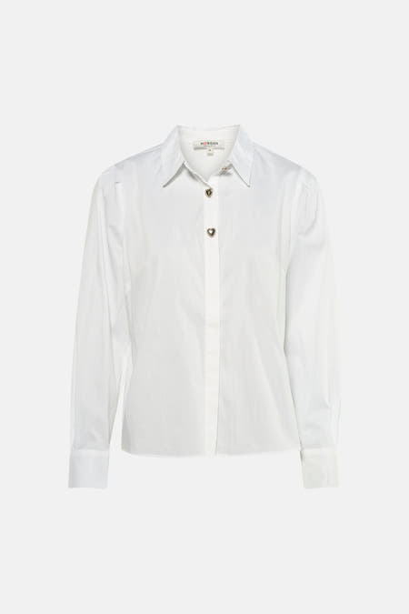 Chemise blanche à manches courtes de Morgan De Toi, avec des boutons en forme de cœur et portée avec un jean et des sandales.