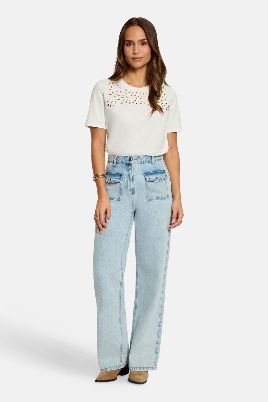 T-shirt blanc à manches courtes de Morgan De Toi, avec perforations décoratives le long de l'encolure, combiné avec un jean bleu clair.