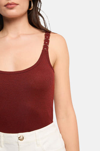 Haut bordeaux avec bretelles spaghetti de Morgan De Toi, avec détails d'anneaux dorés sur les bretelles et pantalon blanc.