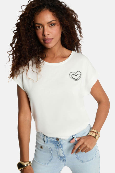 T-shirt blanc à manches courtes de Morgan De Toi, avec une application de cœurs doubles et porté avec un jean et un bracelet en or.