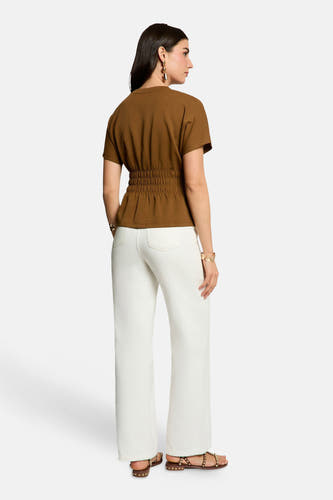Bruine blouse met korte mouwen van Morgan De Toi, elastische taille, achterzijde, model in witte broek en sandalen