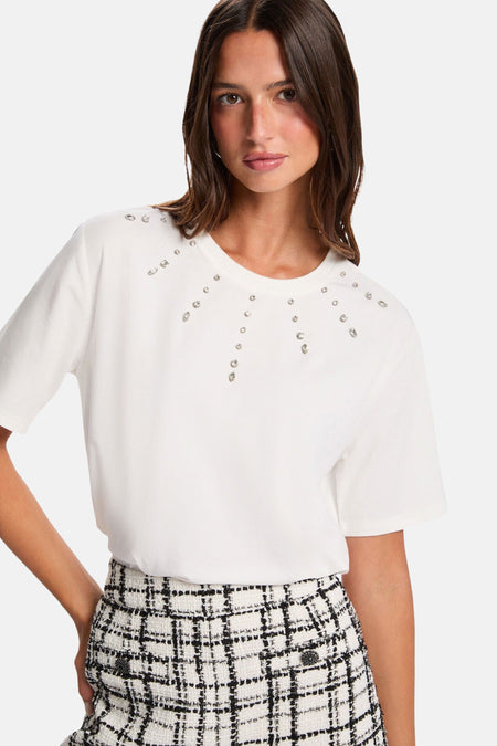 Vrouw in witte blouse en zwart-witte tweed rok.