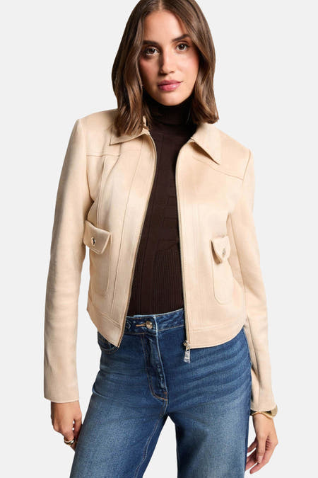 Manteau beige de Morgan de Toi, avec fermeture éclair et poche sur la poitrine, associé à un pantalon brun et des jeans.
