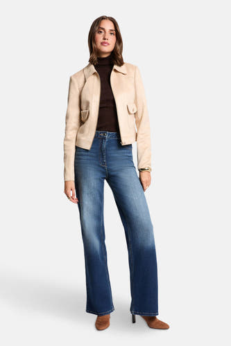 Manteau court beige de Morgan De Toi, avec une veste brune, des jeans à larges poches et des bottines brunes.