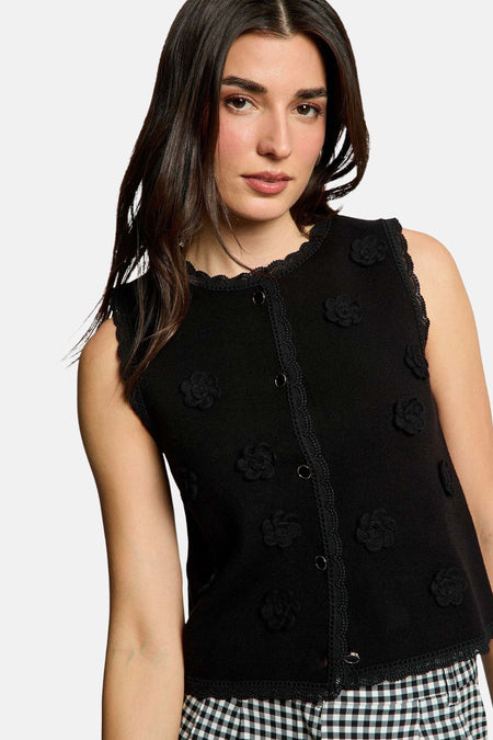 Cardigan noir Morgan De Toi avec détails en dentelle, combiné avec un haut sans manches et un pantalon large à motif carreaux.