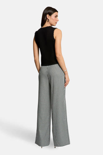 Zwarte cardigan van Morgan De Toi met kanten details, gecombineerd met een mouwloze top en een wijde broek met ruitjespatroon.