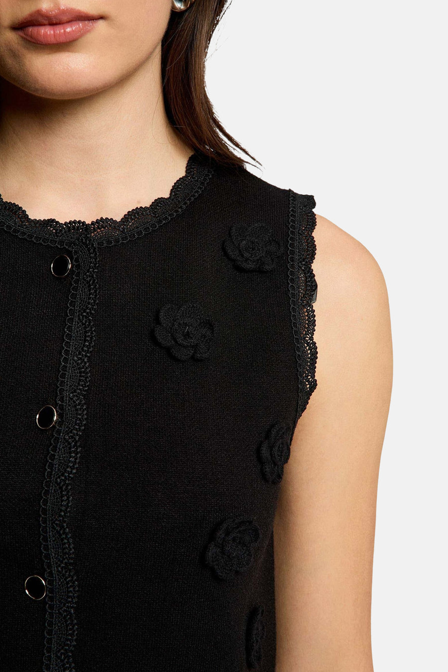Cardigan noir de Morgan De Toi, avec détails en dentelle et applications de roses décoratives.
