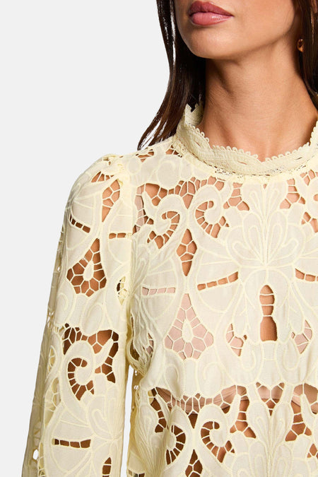 Gele blouse met lange mouwen van Morgan De Toi, met opengewerkt bloemmotief en hoge kraag.