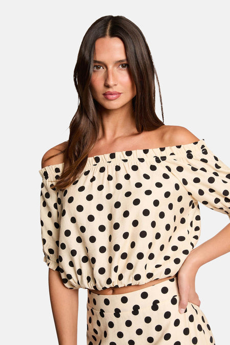 Chemisier multicolore à manches courtes de Morgan De Toi, avec un motif à pois, porté avec des bottes noires.