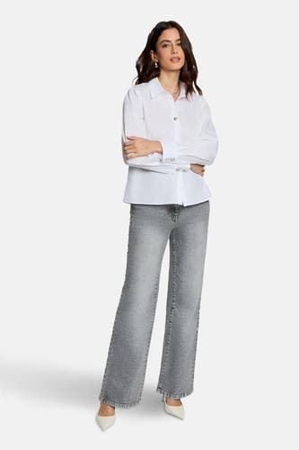 Jean gris large de Morgan De Toi, avec texture denim et larges basques, associé à une blouse blanche et des escarpins.