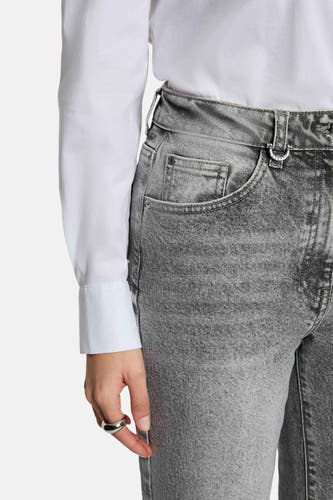 Jean gris large de Morgan De Toi, avec une texture stonewashed, associé à un chemisier blanc et une bague d'argent.