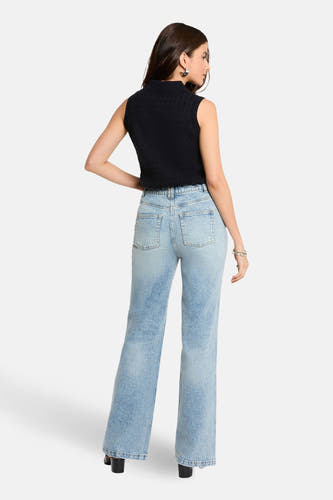 Rechte jeans van midblauw denim van Morgan De Toi, gezien van achteren, met zwarte top en hakken.
