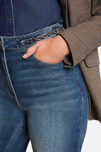 Jean large bleu marine de Morgan De Toi, avec détail de ceinture à chaîne, une main dans la poche, combiné avec une veste à carreaux.