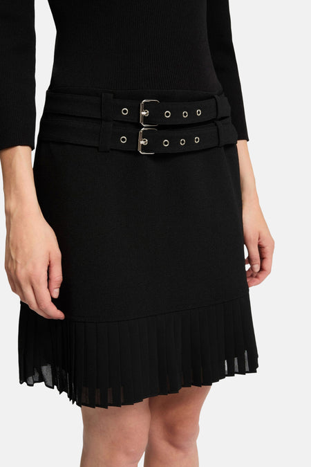 Zwarte jurk met plooienrok en riem.