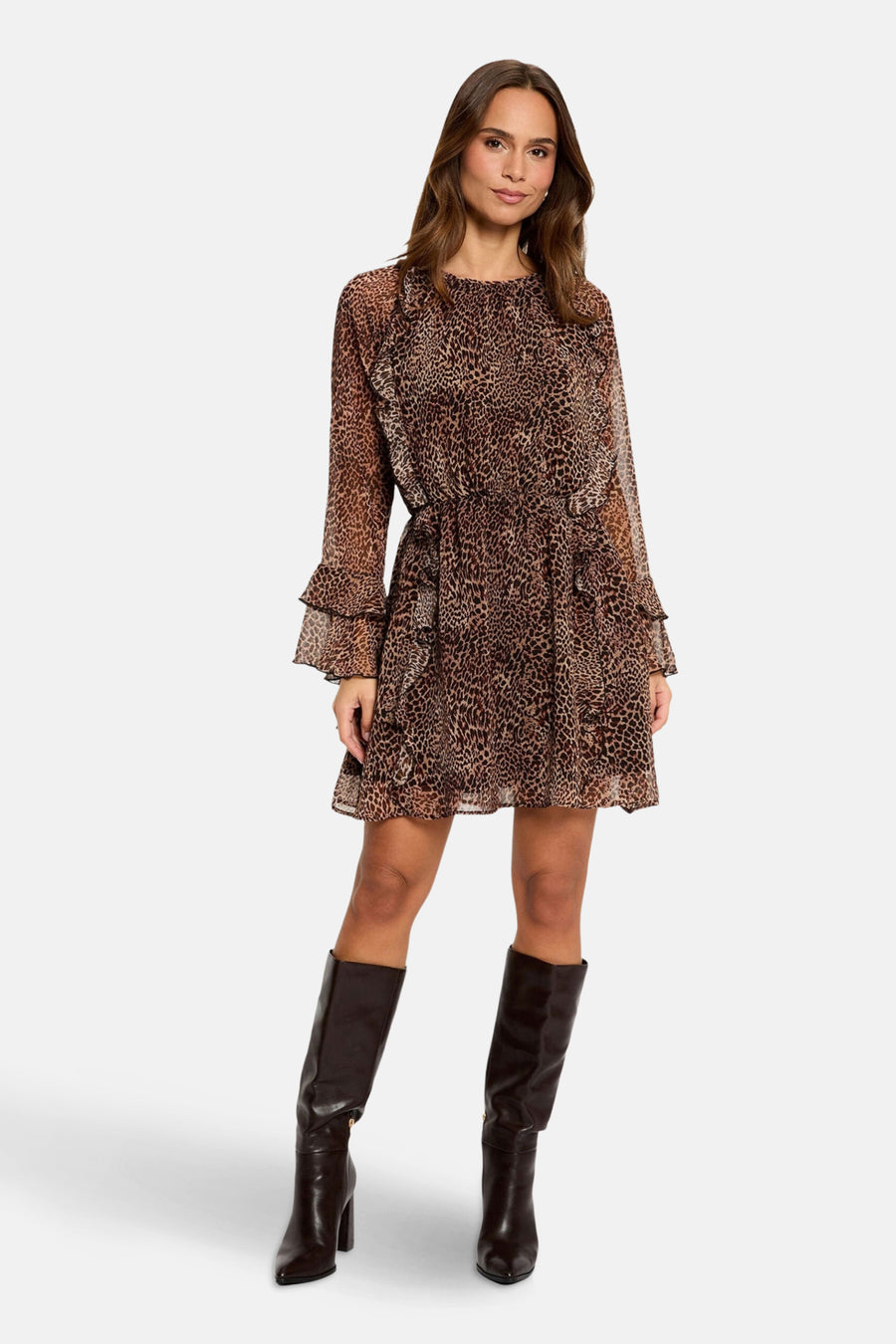 Vrouw in luipaardjurk en bruine laarzen.
