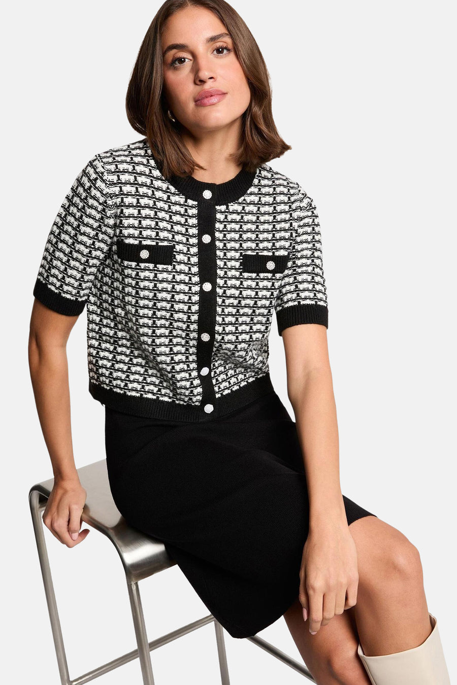 Robe noire à manches courtes de Morgan De Toi, associée à un blouson noir et blanc à boutons.