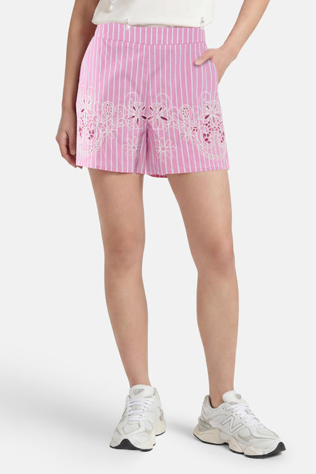 Roze gestreepte shorts met witte bloemen borduurwerk van Morgan De Toi, gedragen met witte sneakers, front view