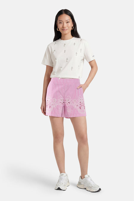 Roze gestreepte shorts met witte kantdetail van Morgan De Toi, gedragen met witte t-shirt en sneakers, front view