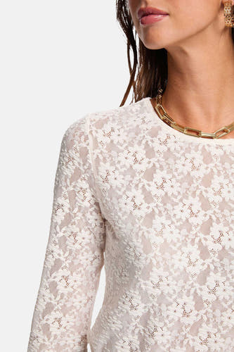 T-shirt écru à manches longues de Morgan De Toi, avec un motif floral sur les bords, associé à une chaîne d'or et des boucles d'oreilles.