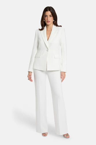 Blazer blanche Morgan De Toi avec fermeture à un bouton, revers et poches à rabat, portée avec un pantalon assorti.