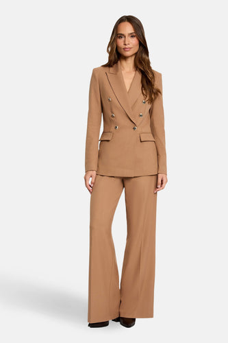 Vrouw in bruin, dubbelknops broekpak.