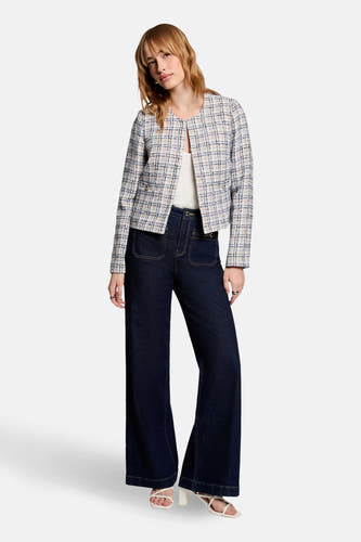 Blouson court bleu de Morgan De Toi, avec un motif rayé, porté avec des jeans pattes d'éléphant et des baskets blanches.