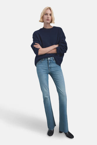 Jean flare bleu clair de MANGO, associé à une chemise bleue marine et des chaussures noires.