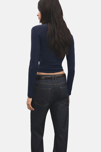 Blauw T-shirt met lange mouwen van MANGO, gezien van achteren, gecombineerd met een donkere broek en een bruine riem.