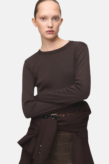 T-shirt marron à manches longues de MANGO, associé à une jupe plissée et un ceinture avec des détails argentés.