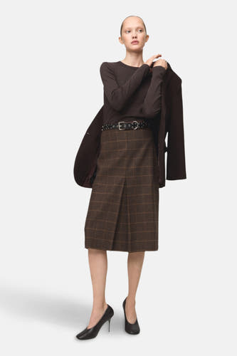 T-shirt marron à manches longues de MANGO, porté avec une jupe évasée et une ceinture noire.