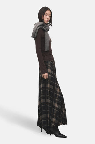 T-shirt marron à manches longues de MANGO, avec un foulard gris décontracté et une jupe plissée.
