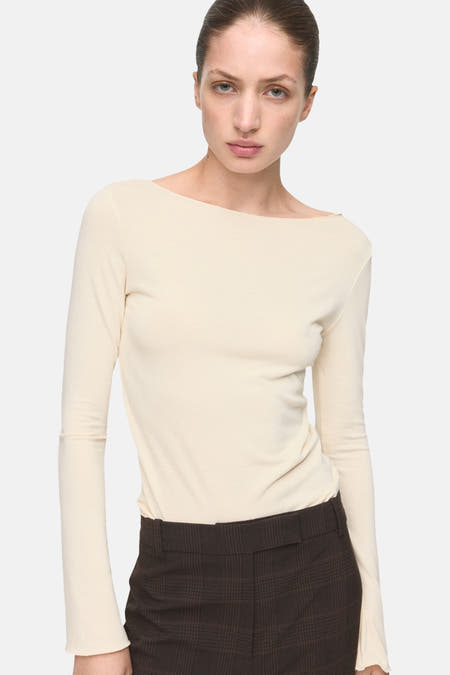 T-shirt écru à manches longues de MANGO, avec une texture lisse et une ligne de col simple.