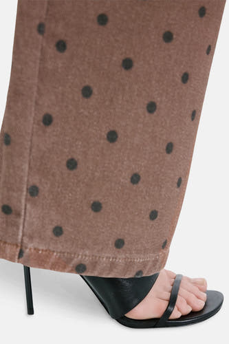 Jeans de couleur marron de MANGO, avec un motif à pois, combinés avec des sandales noires à talons hauts.