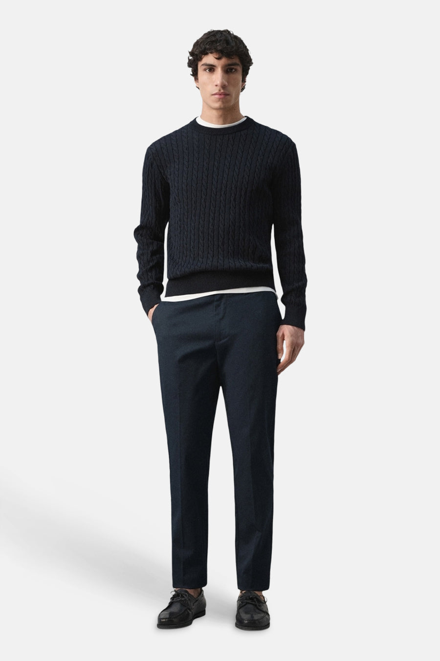Chino bleu de MANGO, combiné avec un pull à torsades et des chaussures en cuir.