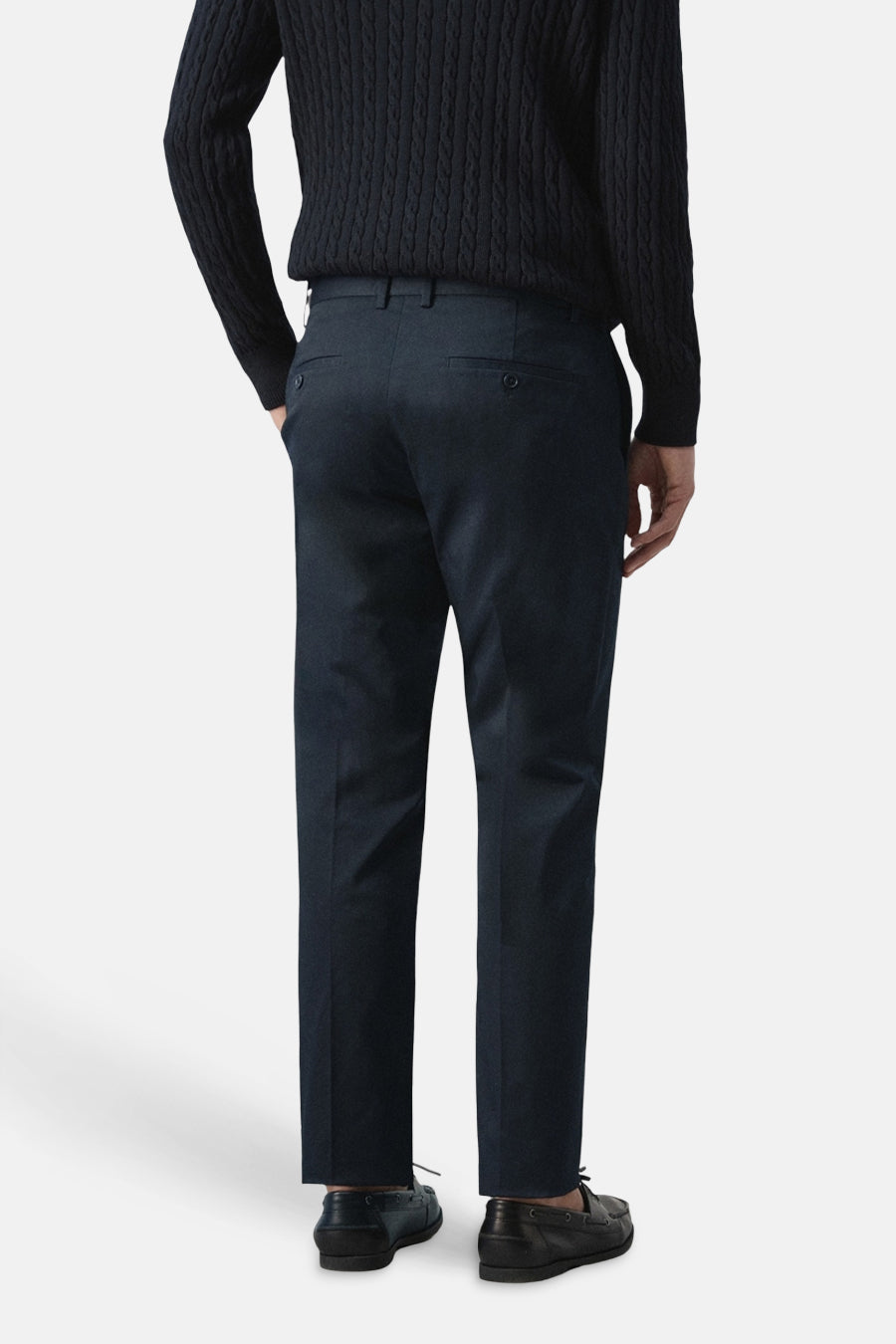 Blauwe chino van MANGO, gezien van achteren, met een effen dessin en donkerblauwe trui.