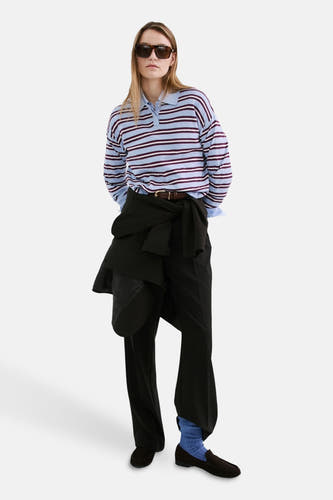 Pull multicolore à col rond de MANGO, rayé et porté avec une chemise à col et un pantalon noir.