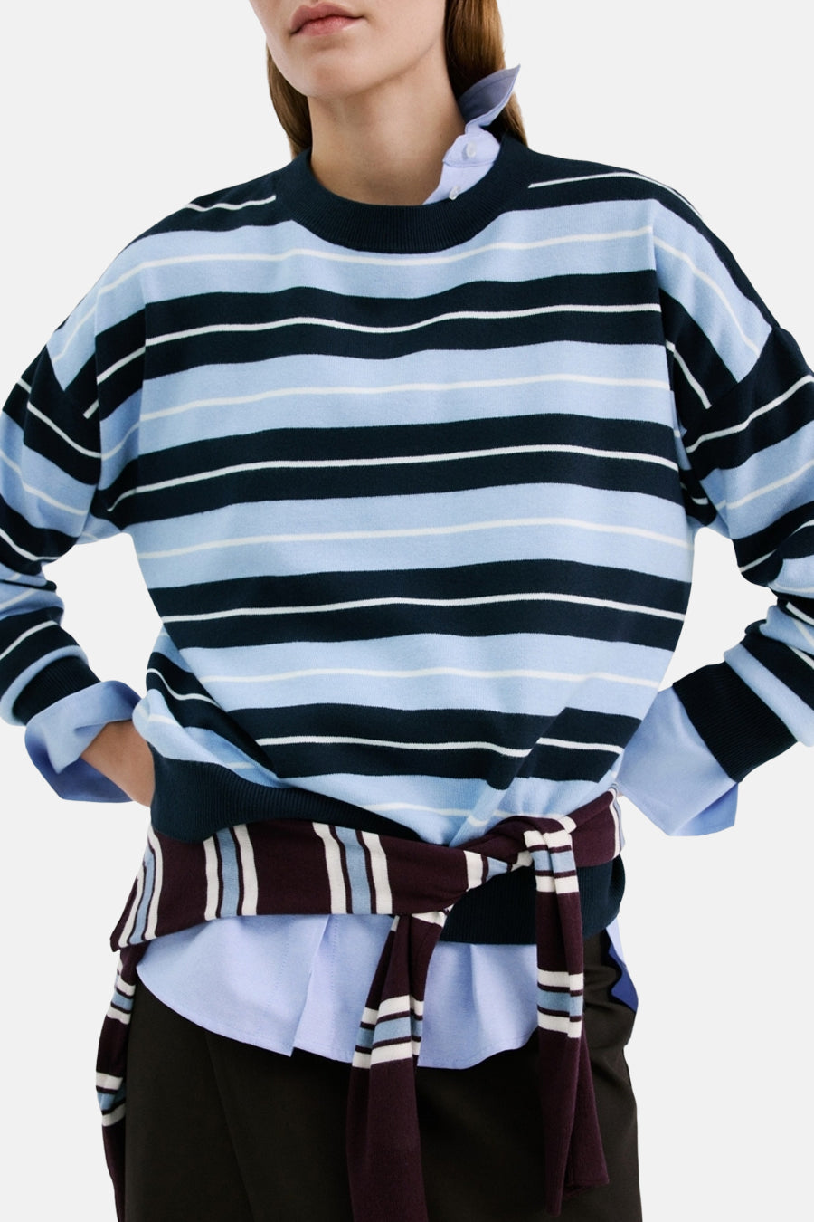 Pull multicolore à col rond de MANGO, avec des rayures bleues et noires et un t-shirt en dessous.