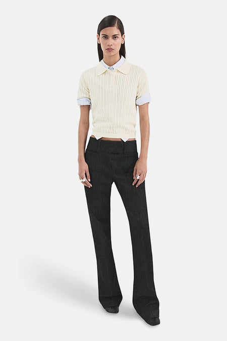 Polo beige de MANGO, porté avec une chemise blanche et un jean foncé.