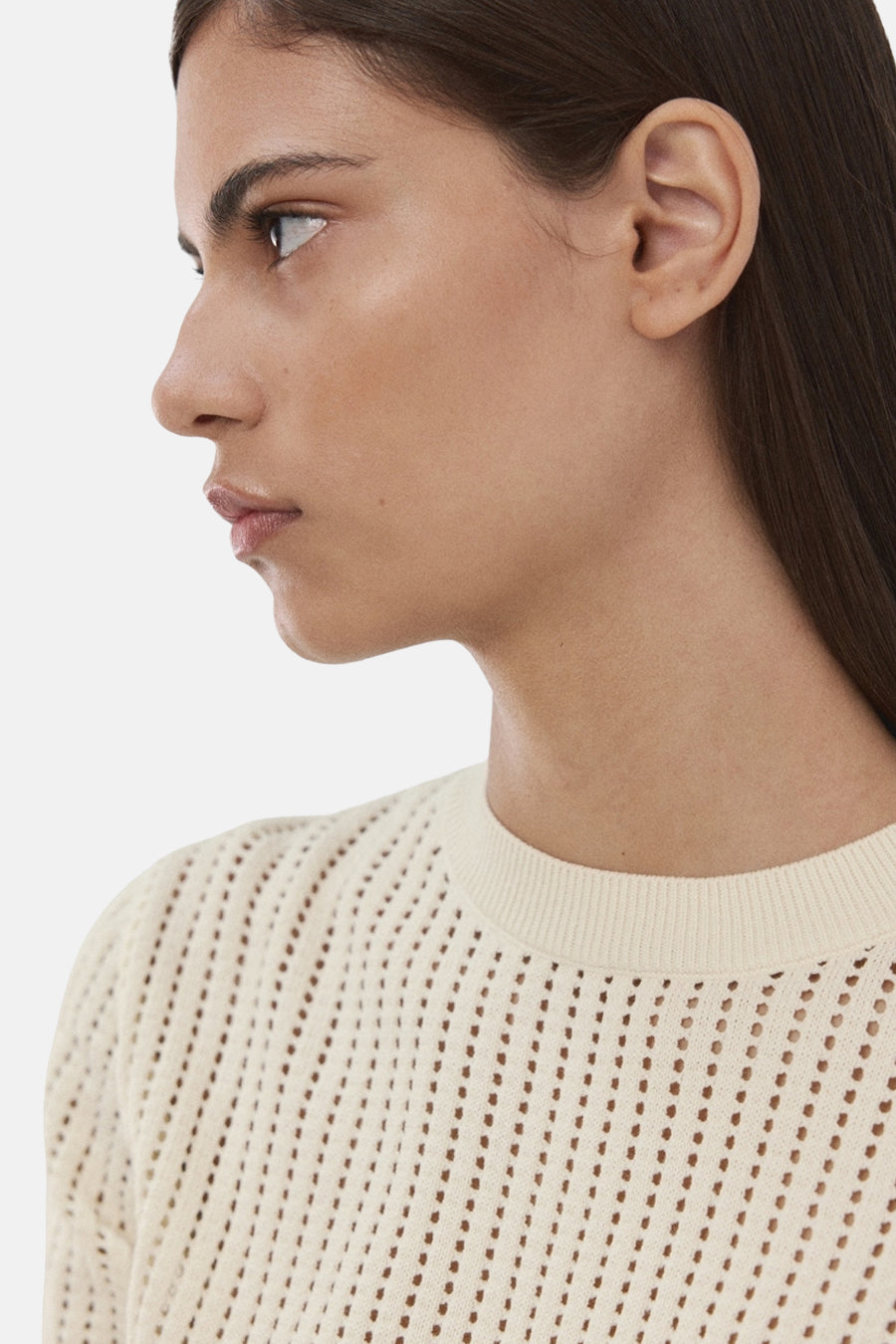 Pull beige à col rond de MANGO, avec un motif ajouré et une texture subtile.