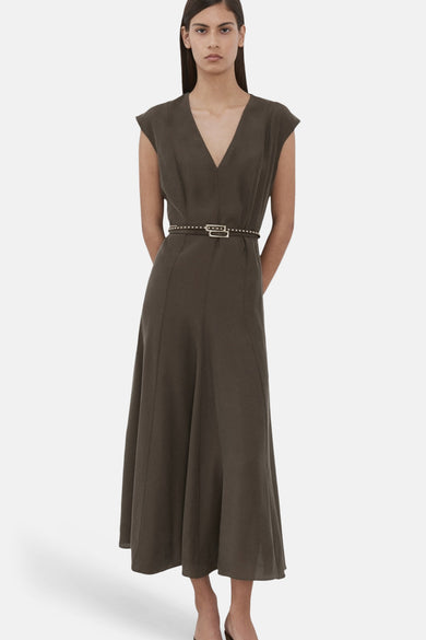 Robe marron sans manches de MANGO, avec une fine ceinture et portée avec des sandales marron.