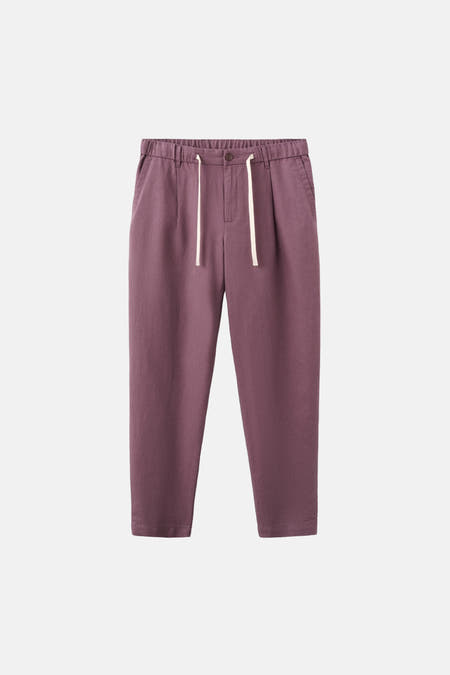 Pantalon violet de MANGO, avec taille élastique et cordons de serrage blancs sur fond blanc.