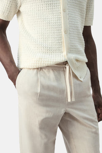 Pantalon écru de MANGO, avec cordon de serrage à la taille et plis sur le devant.
