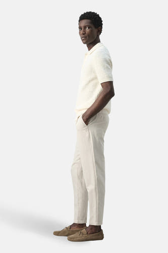Pantalon écru de MANGO, avec une texture légère et une coupe décontractée.